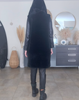 Manteau fausse fourrure noire à capuche sans manche.