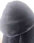 Manteau fausse fourrure noire à capuche sans manche.