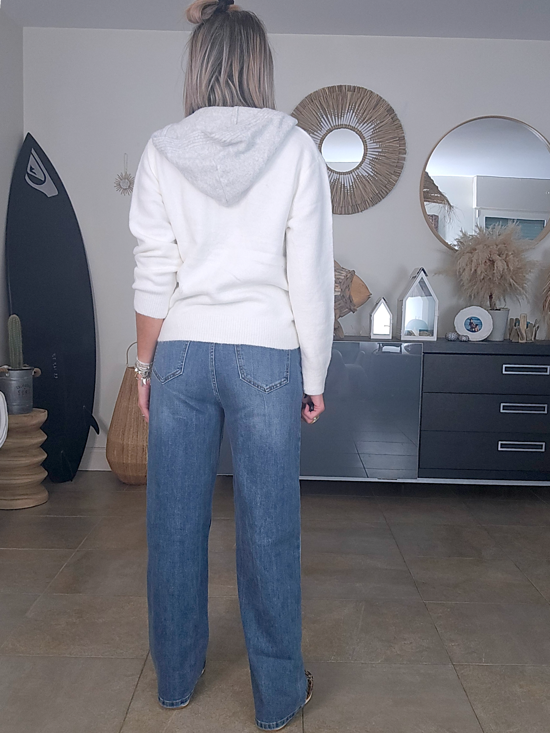 Jean bleu coupe droite à ceinture asymétrique.