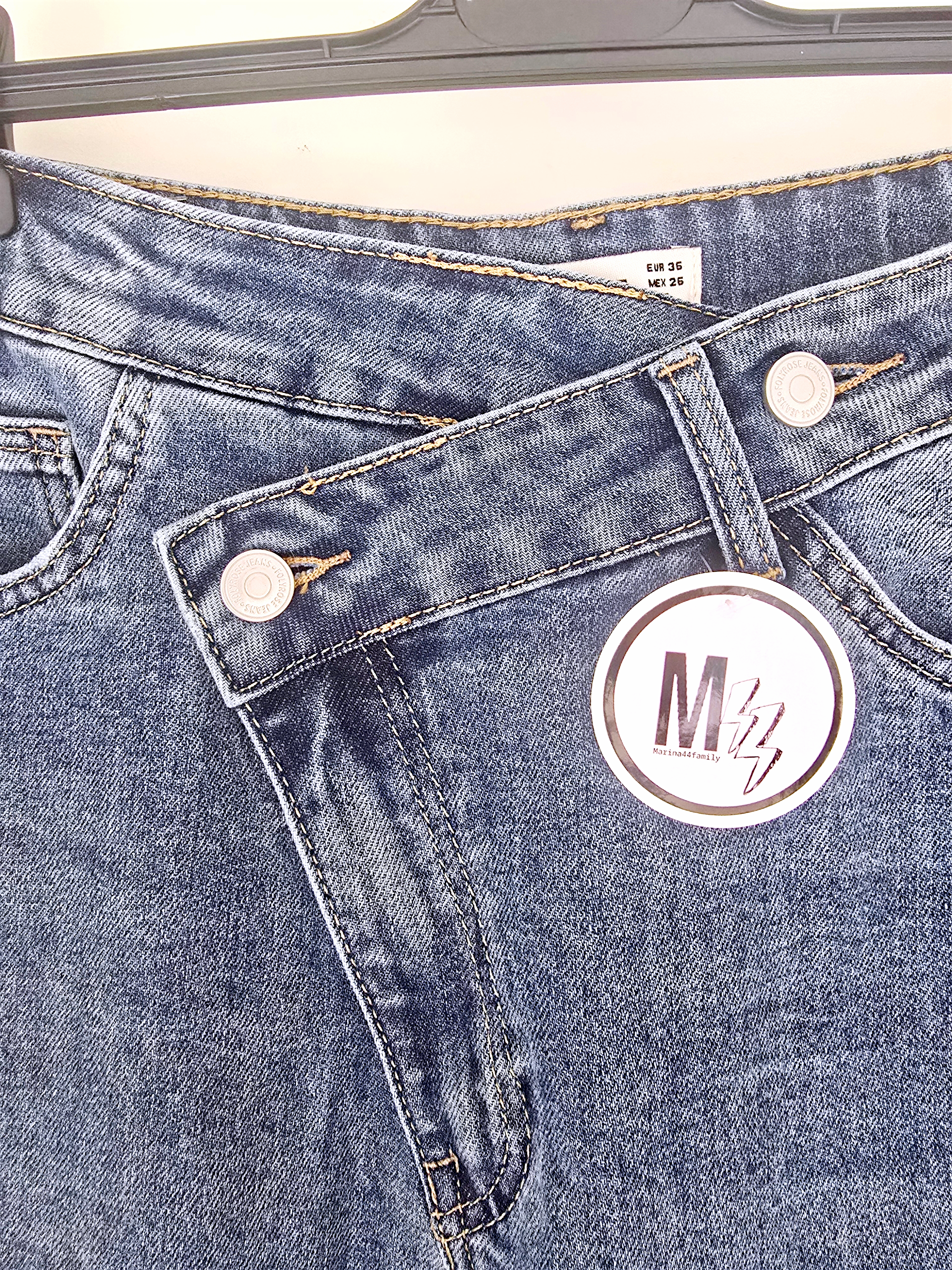 Jean bleu coupe droite à ceinture asymétrique.