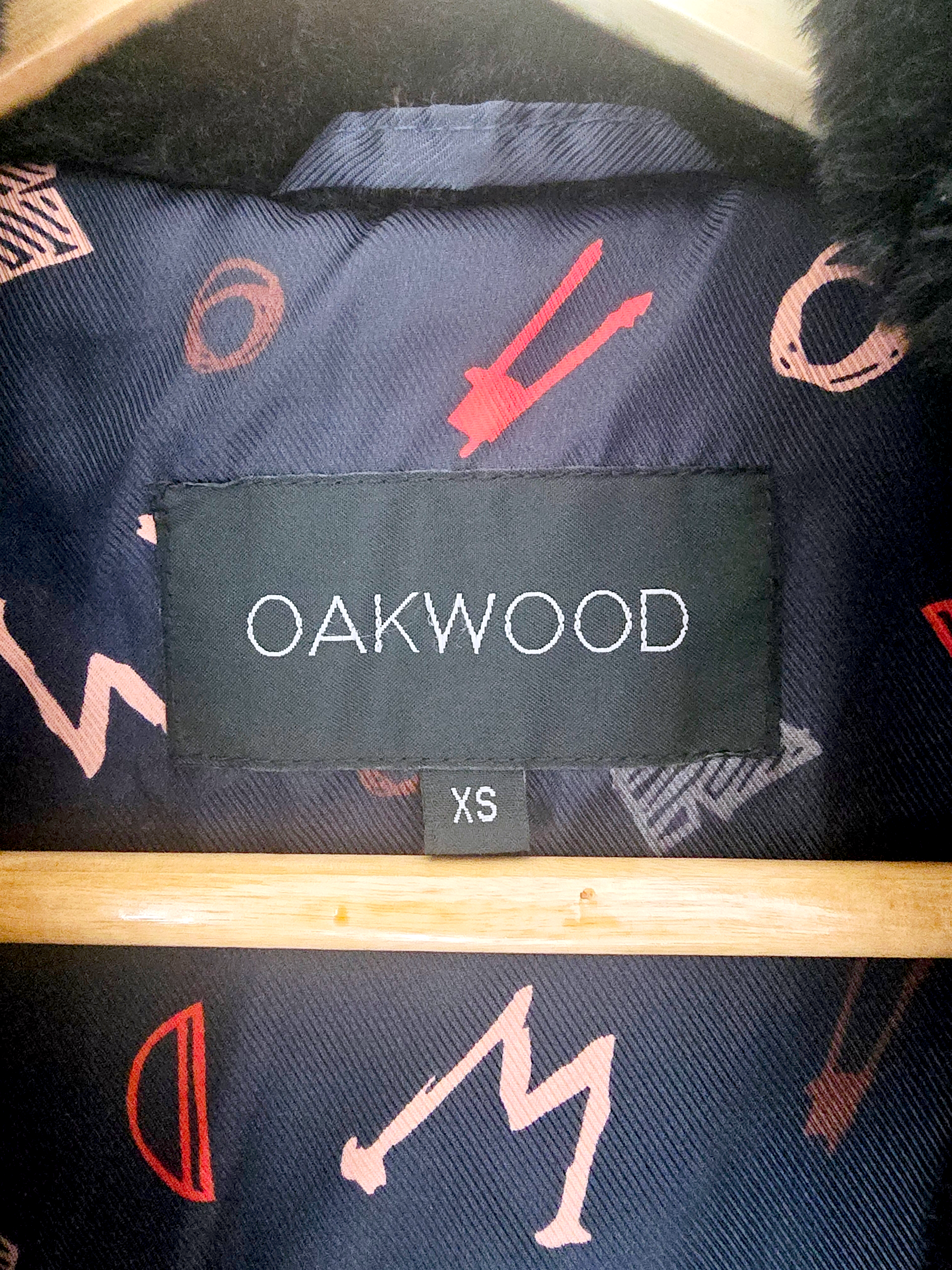 Manteau fausse fourrure noire à capuche sans manche.