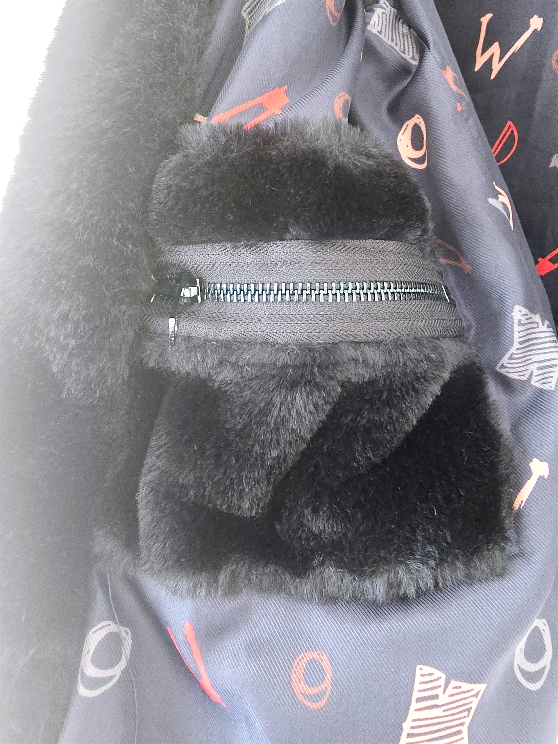 Manteau fausse fourrure noire à capuche sans manche.