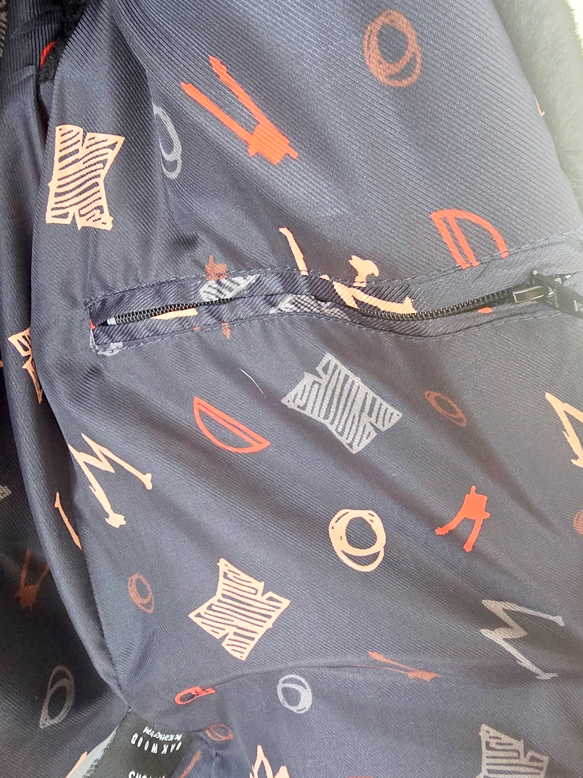 Manteau fausse fourrure noire à capuche sans manche.