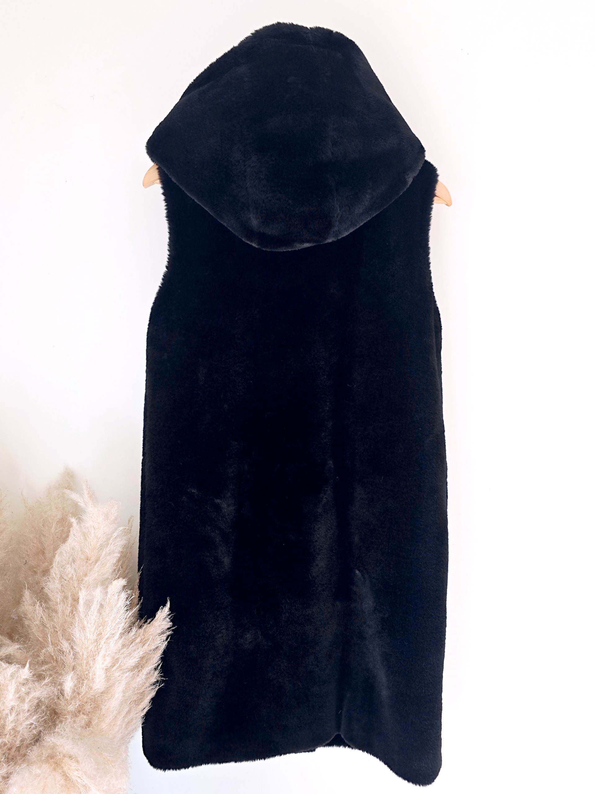 Manteau fausse fourrure noire à capuche sans manche.