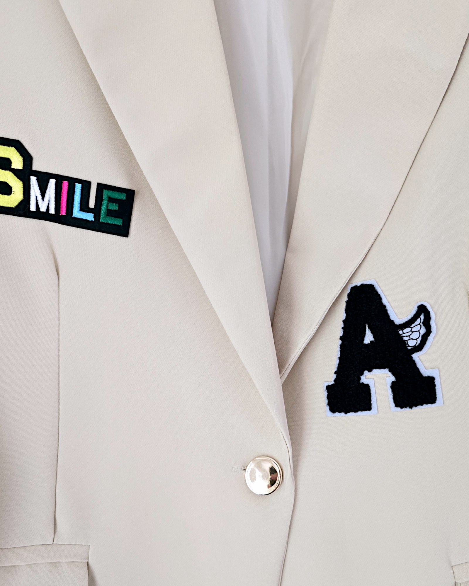 Veste beige à écussons