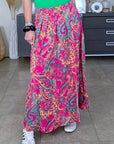 Jupe longue fendue rose fuchsia à imprimé.