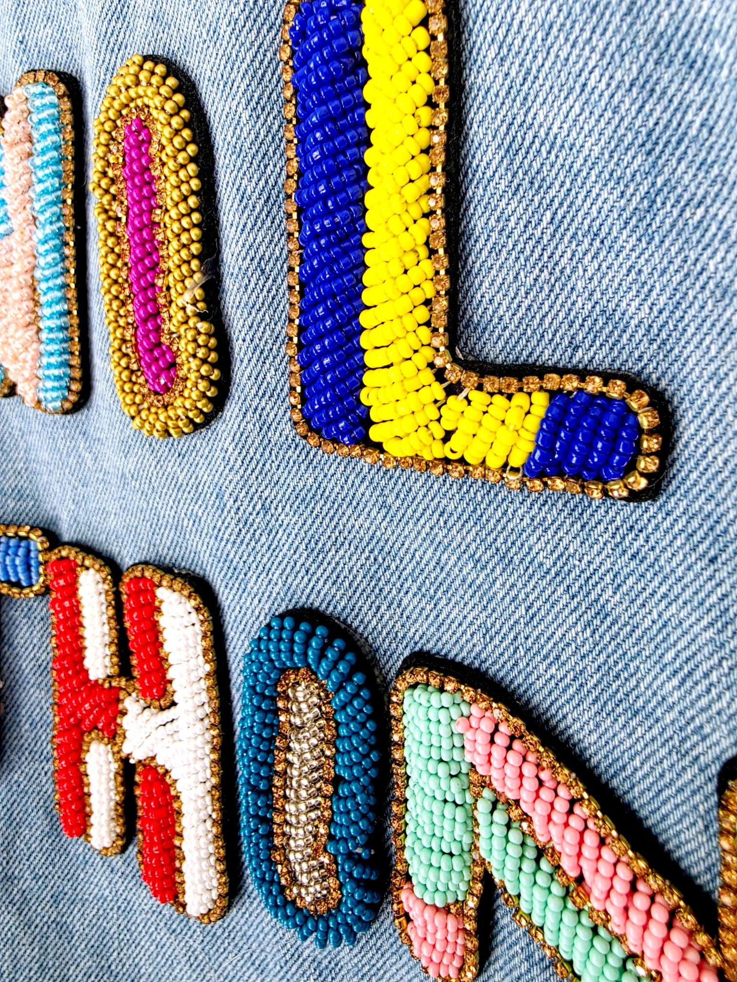 Veste en jean avec inscriptions perlées au dos