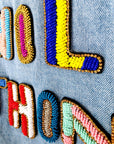 Veste en jean avec inscriptions perlées au dos