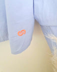 Chemise bleu ciel à palmiers orange fluo